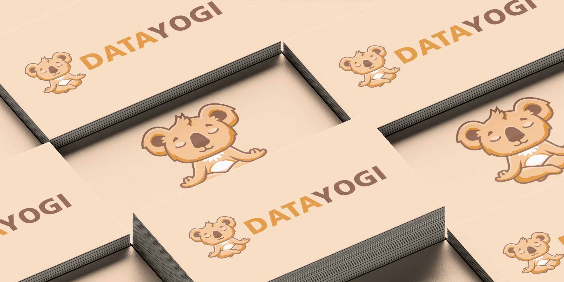 A stack of peach business cards designed by our design agency is shown. They show a meditating koala and the words "DataYogi".