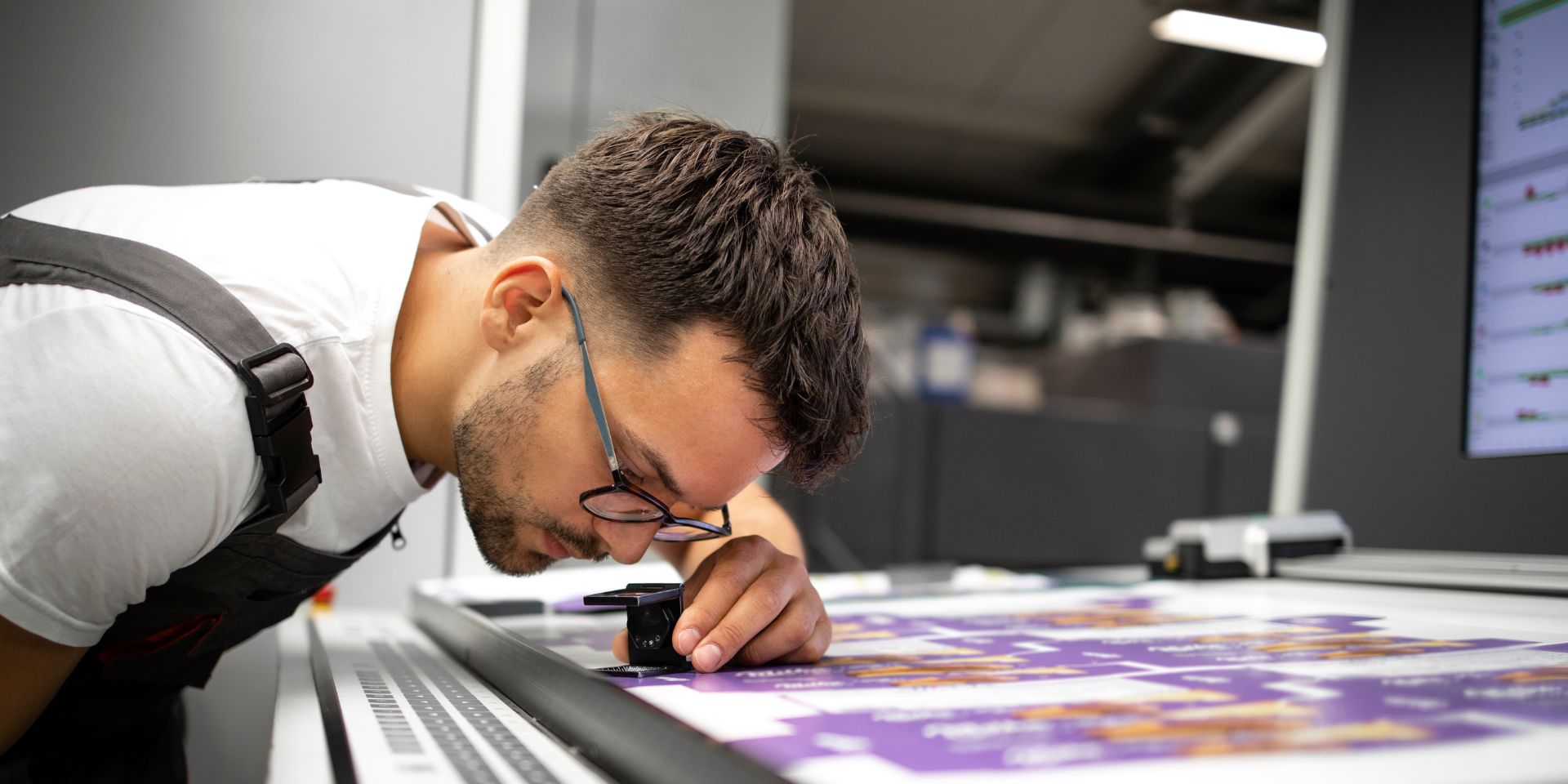 A printing professional inspects the print run of print marketing.