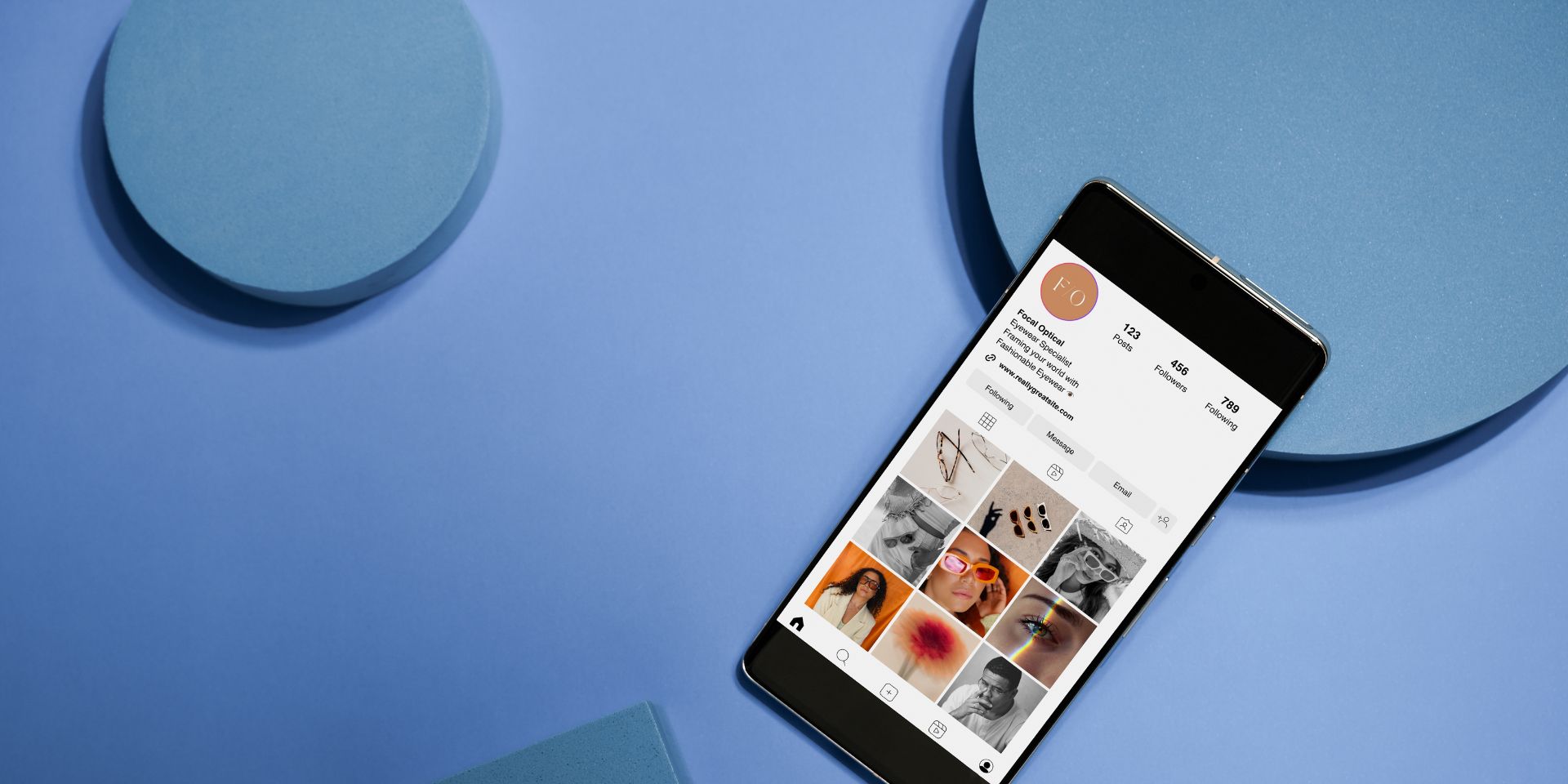 Awards – do they mean anything? Image of a mobile phone displaying an Instagram feed. The solid mid-blue background has circles showing.