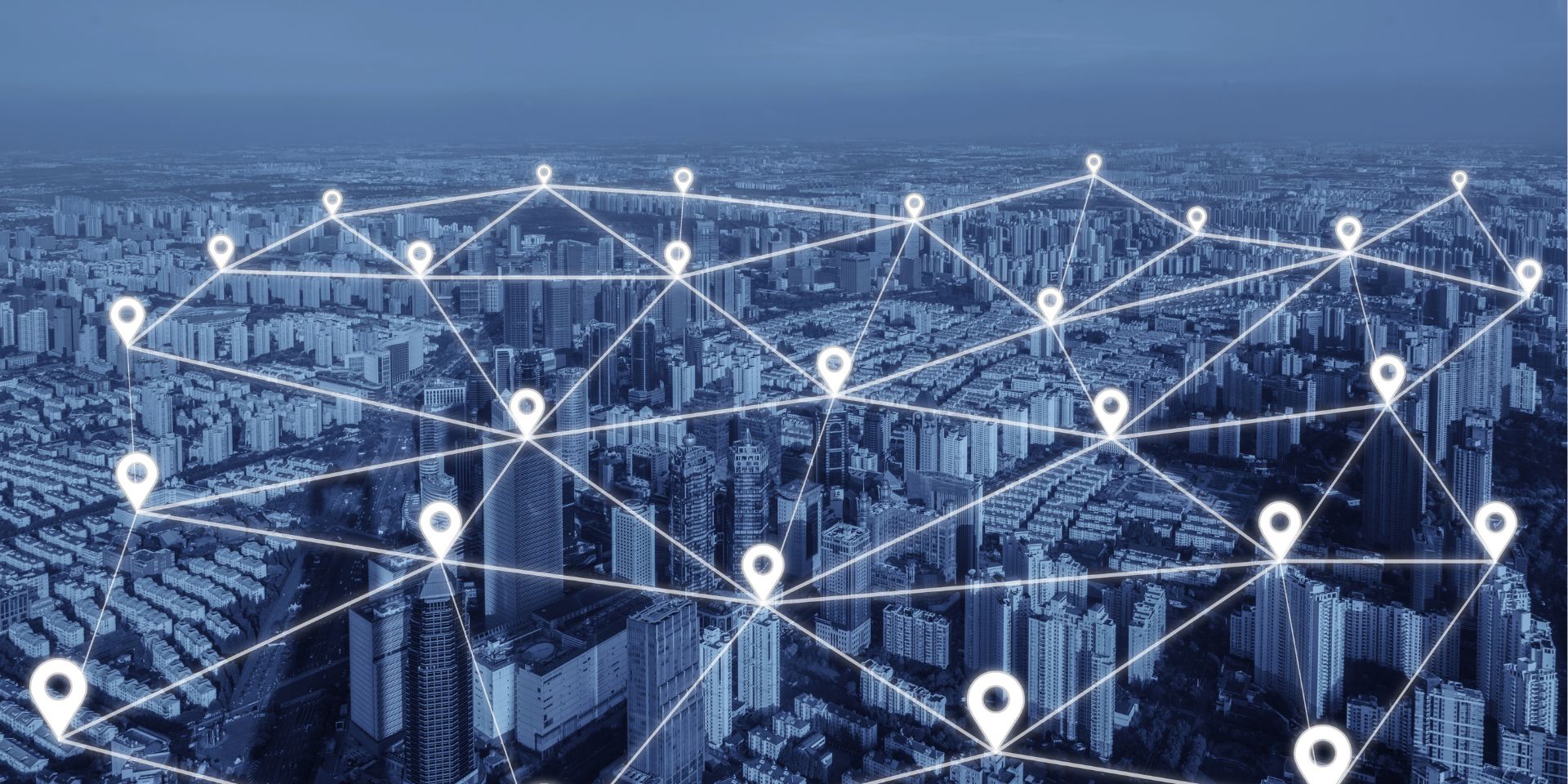 A navy blue background of a high rise city is covered by a web network of location pins in white.